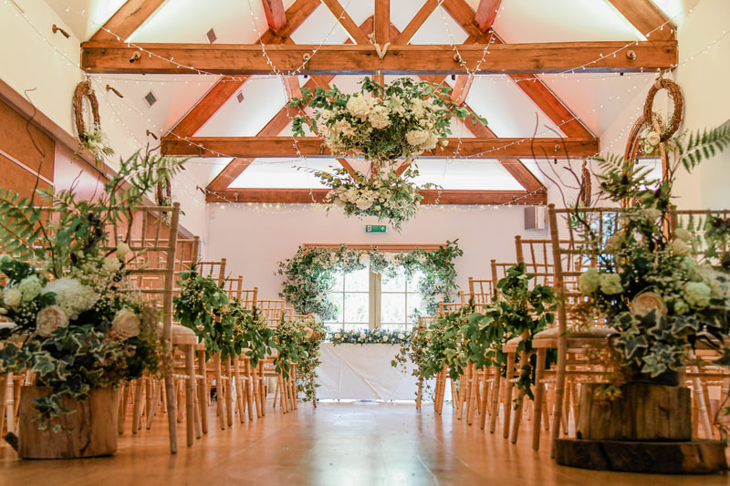 Chipping Camden Barn ceremony room. White flowers ceremony room decorations.