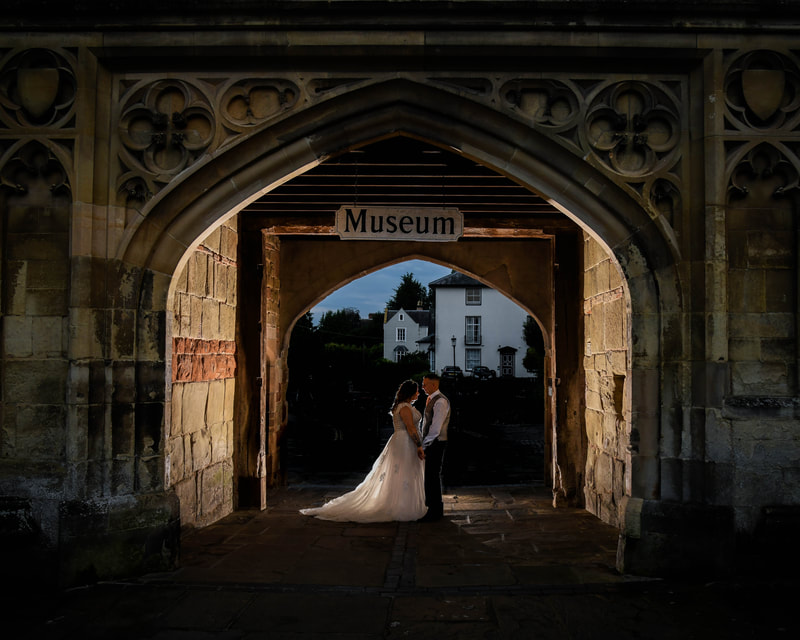 Malvern wedding, bride and groom portrait under Malvern Museum arch.